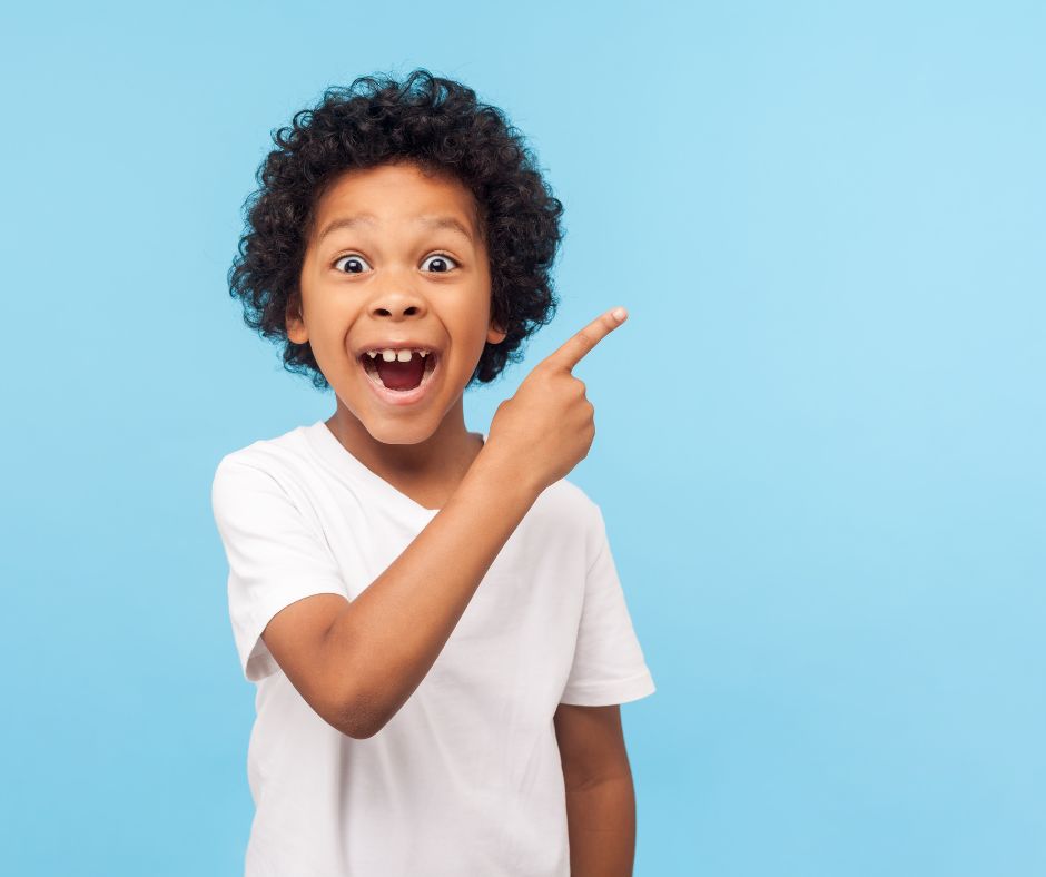 excited boy pointing with a blue background