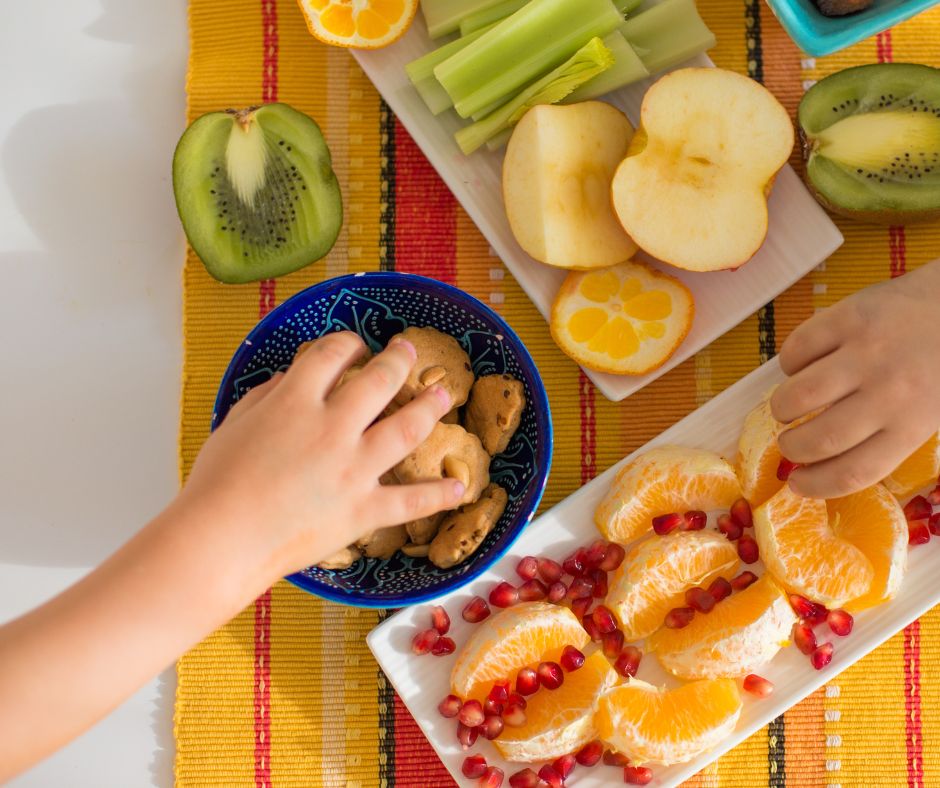 kids hands reaching onto a table full of fruit